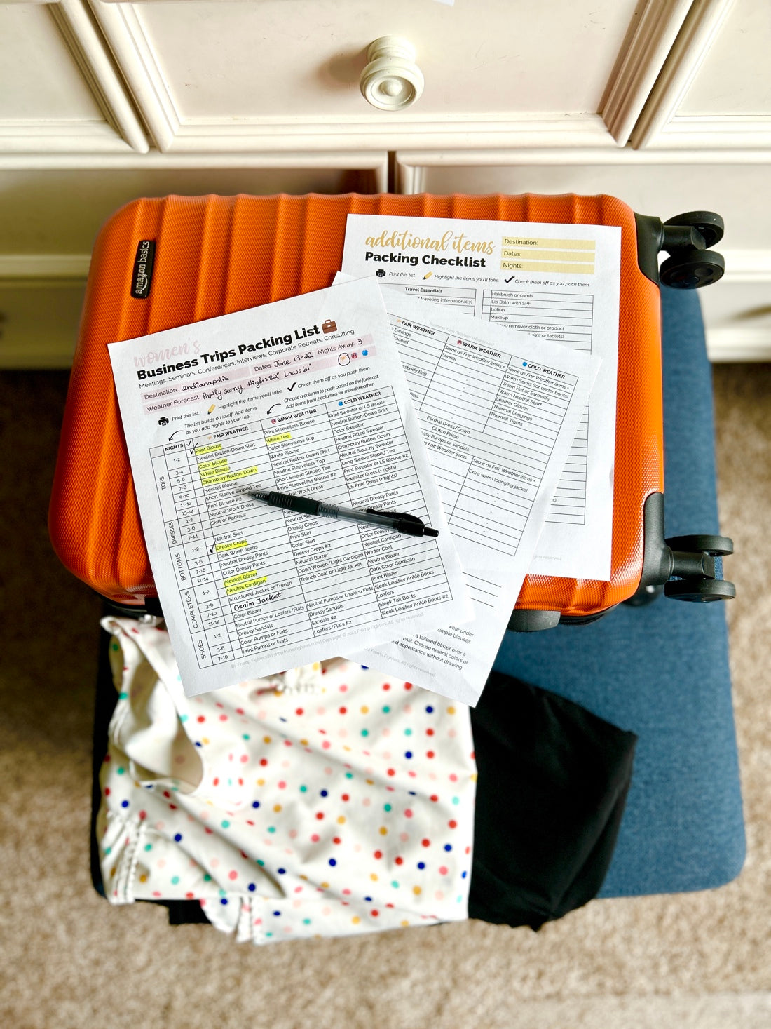 Packing printables next to luggage with clothes as traveler packs for trip with Packing Made Easy printable packing lists.