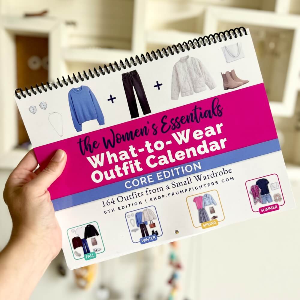 Holding spiral bound Core Edition "What to Wear" Outfit Calendar showing cover 