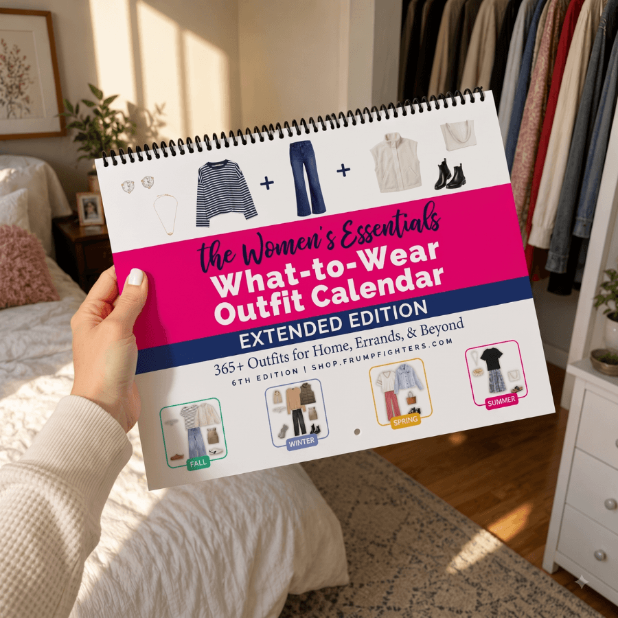 Woman holding the Women's Essentials capsule wardrobe outfit calendar in her bedroom beside an open closet